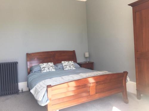 a bedroom with a wooden bed with two pillows at Collingwood House Tynemouth in Tynemouth