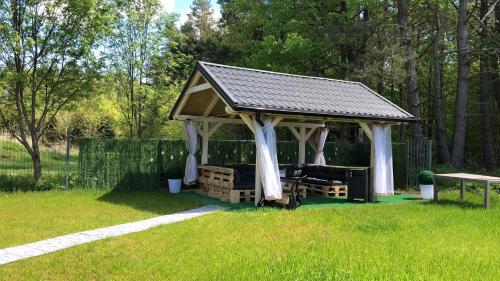a gazebo with a couch in a yard at Comfort Zone Ostróda Ruś Mała in Ostróda