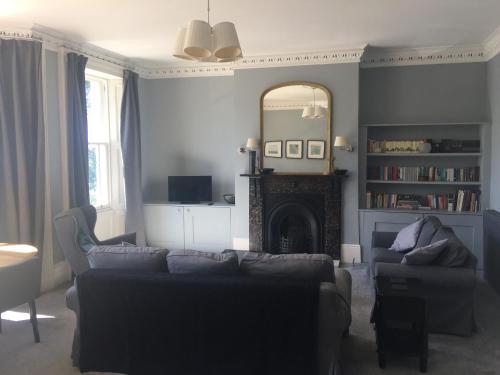 a living room with a couch and a mirror at Collingwood House Tynemouth in Tynemouth