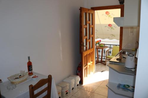 a kitchen with a table and a door to a room at Michalis Studios in Lipsoi