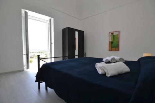 Un dormitorio con una cama azul con toallas. en Casa Pinuccia guest house, en Rosolini