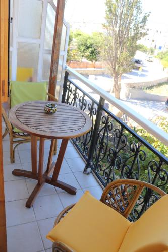 a wooden table and chairs on a balcony at Michalis Studios in Lipsoi