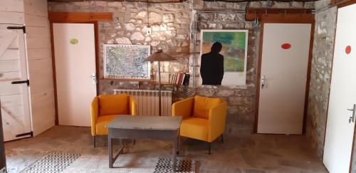 a living room with two chairs and a table at Alberg Rural La Rectoria de Pedra in Bellver de Cerdanya 