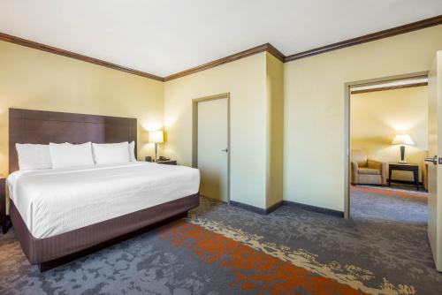 a bedroom with a large bed and a room with a couch at La Quinta by Wyndham Eastland in Eastland