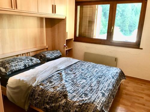 ein Schlafzimmer mit einem Bett mit zwei Kissen darauf in der Unterkunft Appartamento chalet in Laax