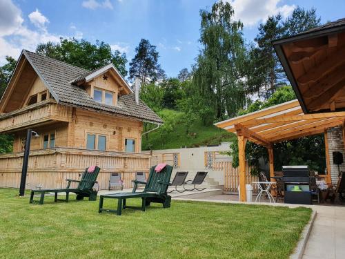 un patio trasero con sillas, una parrilla y una casa en Planika Holiday Home en Bled