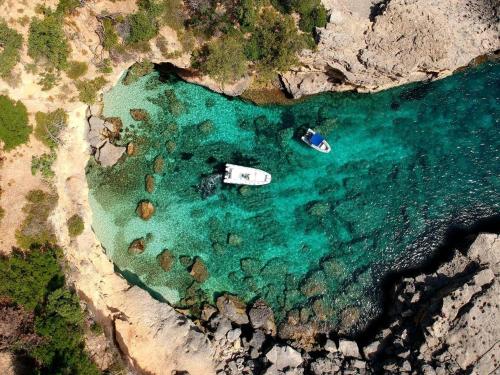 an aerial view of a beach with a boat in the water at Affittacamere Le Ginestre in Cala Gonone