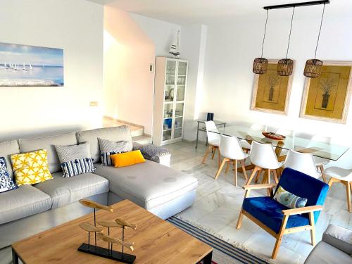 een woonkamer met een bank en een tafel bij PLAYA PALOMA Beach House 8PAX in Estepona