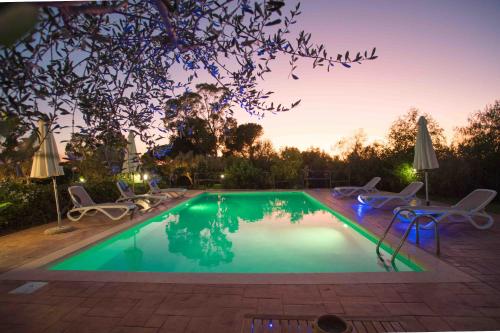 a swimming pool with chairs and a table at Pietre Rosse Sicule - case vacanze Elena e Marta in Montevago