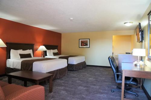 ein Hotelzimmer mit 2 Betten, einem Tisch und Stühlen in der Unterkunft McMinnville Inn in McMinnville