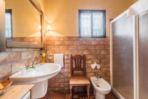 a bathroom with a sink and a toilet and a tub at Finca El Cotillo in Linares