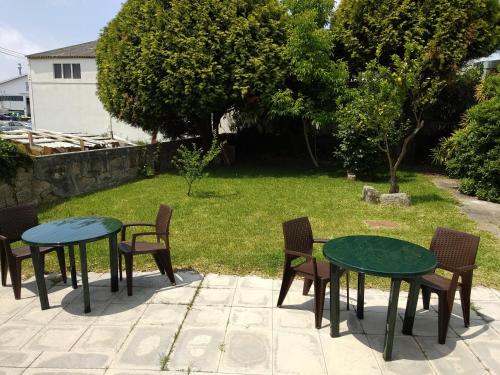 a patio with two tables and chairs in a yard at AirPorto Hostel in Maia
