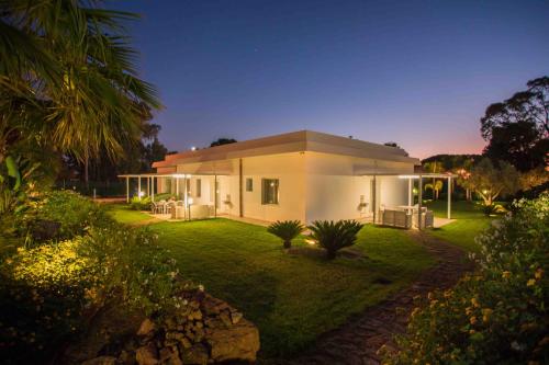 a white house with a garden at night at Pietre Rosse Sicule - case vacanze Elena e Marta in Montevago