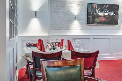 a dining room with a table with wine glasses at Hotel Stadt Mühlhausen in Mühlhausen
