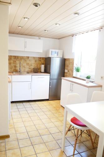 a kitchen with white cabinets and a table at #Hoenepartment - TimeOut Waldhessen - bis zu 8 Pers. in Hönebach