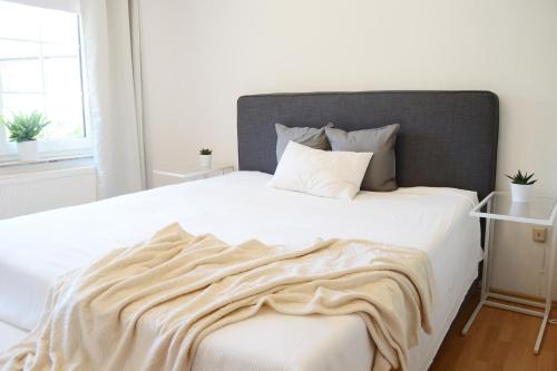 a bedroom with a large white bed with a blanket on it at #Hoenepartment - TimeOut Waldhessen - bis zu 8 Pers. in Hönebach