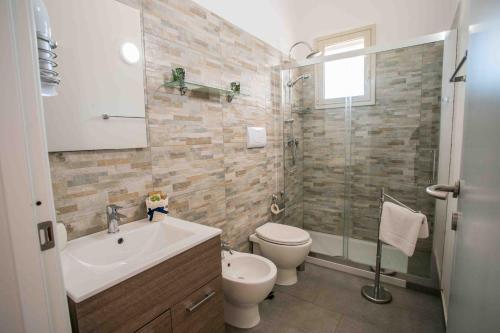 a bathroom with a toilet and a sink and a shower at Pietre Rosse Sicule - case vacanze Elena e Marta in Montevago