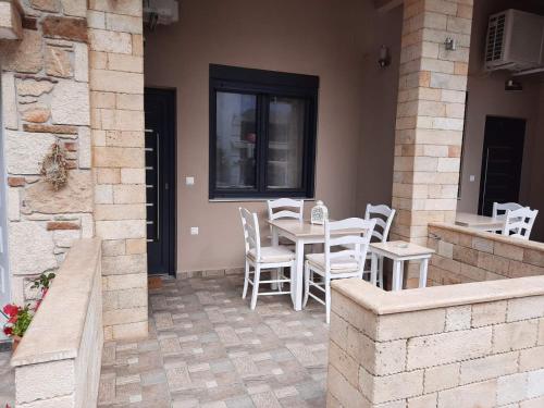 a patio with a table and chairs and a building at Evdokia's Apartments and Rooms in Neos Marmaras