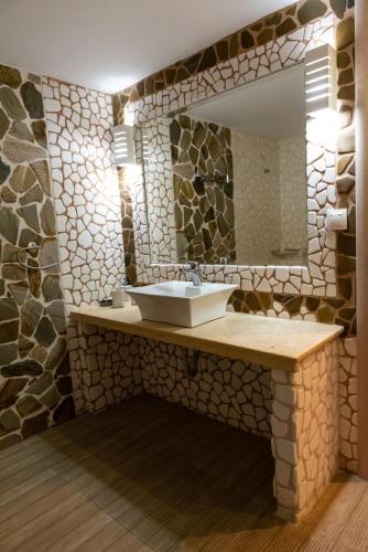 a bathroom with a sink and a mirror at Evdokia's Apartments and Rooms in Neos Marmaras