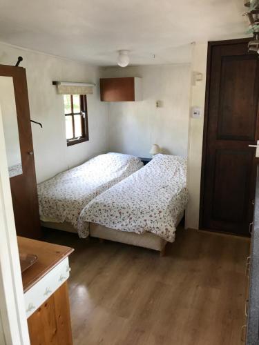 a bedroom with two beds and a wooden floor at Chalet westerham in Winsum