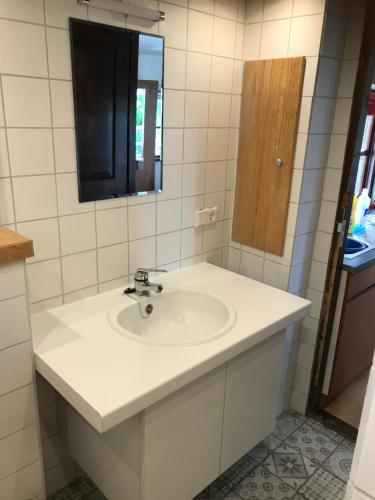 uma casa de banho com um lavatório branco e um espelho. em Chalet westerham em Winsum