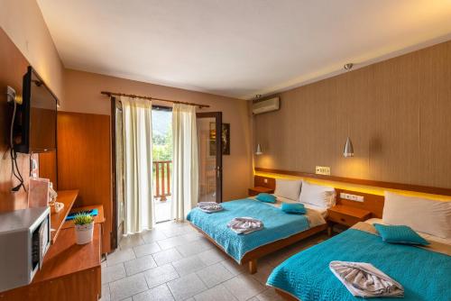 a hotel room with two beds and a television at Porto Marina in Chrysi Ammoudia