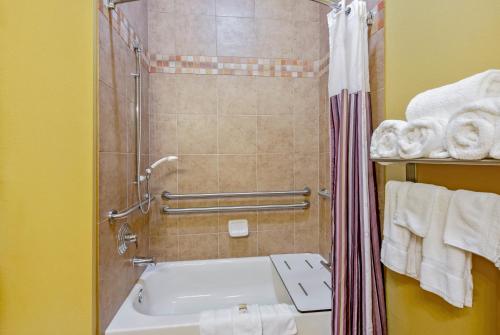 a bathroom with a sink and a shower with towels at La Quinta by Wyndham Eastland in Eastland