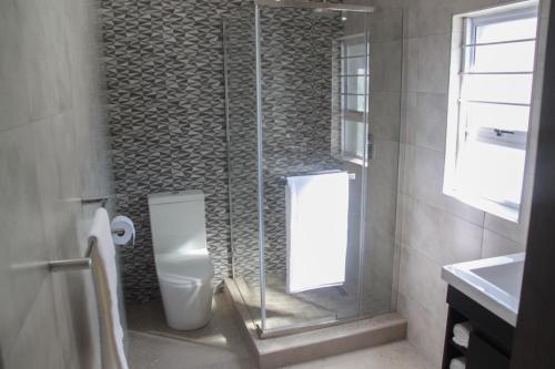 
a bathroom with a toilet, sink and tub at The Cato Suites Hotel in Durban
