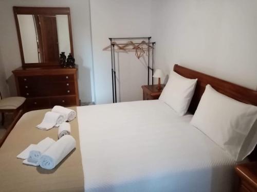 a bedroom with a white bed with towels on it at Adega dos Virgilios in Madalena