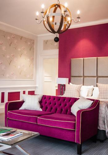 a purple couch in a room with a pink wall at Barnett Hill Hotel in Guildford