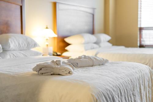 three white towels are sitting on a bed at Temple Gardens Hotel & Spa in Moose Jaw