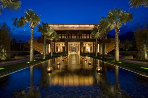 a building with palm trees in front of a pool at Narada Resort & Spa Perfume Bay Sanya - All Villas in Lingshui