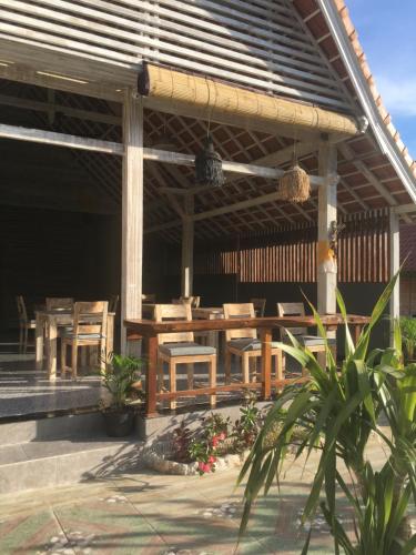 a patio with a wooden table and chairs at Le Biu garden View in Nusa Lembongan
