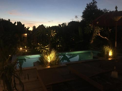 a swimming pool at night with lights at Le Biu garden View in Nusa Lembongan