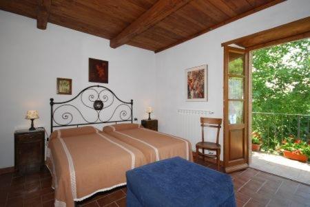 Agriturismo Ombianco في Seggiano: غرفة نوم بسرير ونافذة كبيرة
