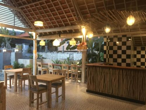 a restaurant with tables and chairs and a bar at Le Biu garden View in Nusa Lembongan