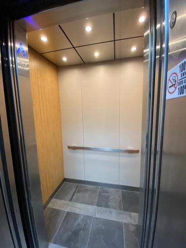 a walk in closet with a glass door and a tile floor at Hotel Paris in Tijuana