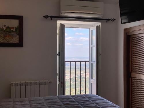 a bedroom with a door open to a balcony at Varanda Do Alentejo in Marvão