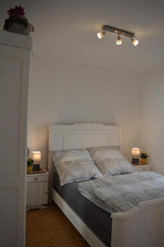 1 dormitorio con 1 cama blanca y 2 mesitas de noche en Ludwig XIV, en Saarlouis