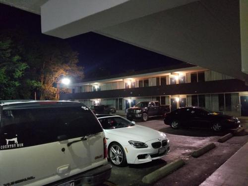 two cars parked in a parking lot in front of a building at Motel 6 Morgantown in Morgantown