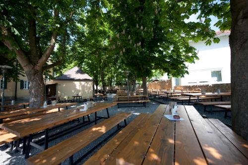 a group of wooden benches in a park with trees at Hotel Wirtshaus Garbe in Stuttgart