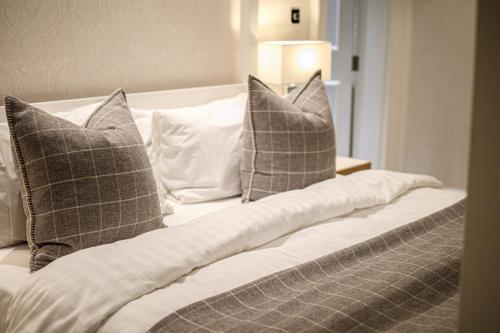 a bed with two pillows and a blanket at Barnett Hill Hotel in Guildford