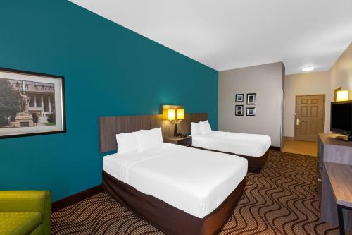 a hotel room with two beds and a television at La Quinta by Wyndham Midland North in Midland