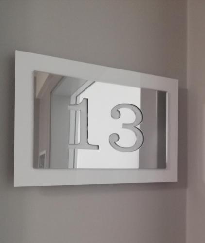 a mirror with the number three on a wall at APARTAMENTY POSEJDON in Świnoujście