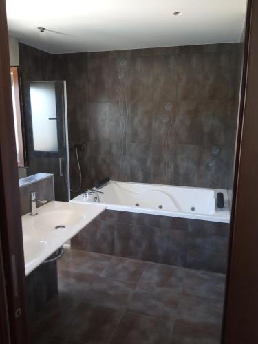 a bathroom with two sinks and a bath tub at Villa Madodos con piscina privada, jacuzzi, barbacoa y chimenea in Riofrío