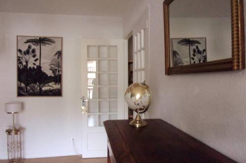 a room with a table with a mirror and a lamp at Appartement VILLA PAULA Ax-les-Thermes in Ax-les-Thermes
