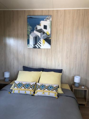 a bedroom with a bed with a picture above it at La Cabane in Draguignan