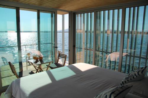 フゼタにあるBarco Casa Fuzetaのベッドがあり水辺の景色が見える寝室