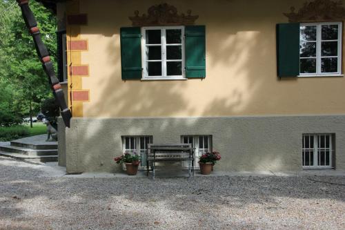 a building with a bench and a window and flowers at Villa Zollhaus Bed & Breakfast in Türkheim
