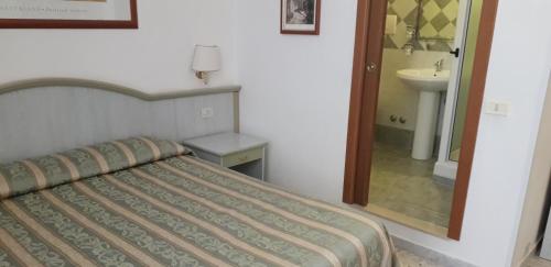 sypialnia z łóżkiem, umywalką i lustrem w obiekcie Gioia Guest House w Rzymie